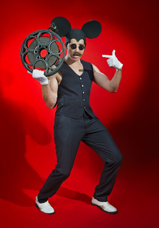 Man in a hat of a mouse with a reel of filmの写真素材