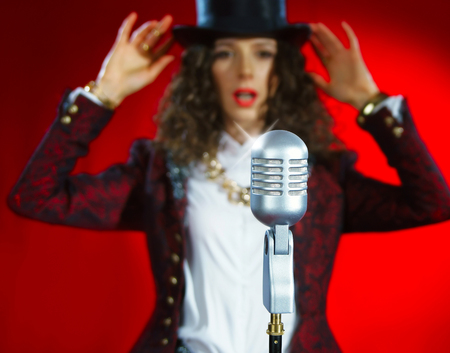 Singer girl with microphone on the red backgroundの写真素材
