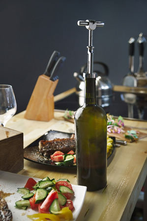 Roast meat steak in a plate with vegetables and wine bottleの写真素材