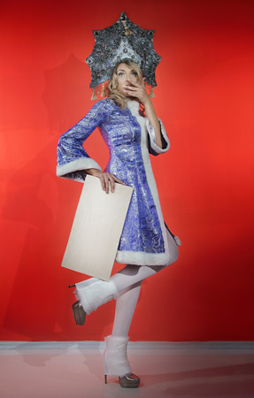 Astonishment snow maiden in a openwork blue crown and coat with a white nameplate in his handsの写真素材