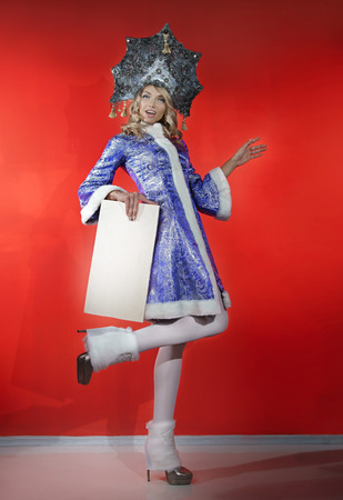 Beautiful snow maiden in a openwork blue crown and coat with a white nameplate in his handsの写真素材