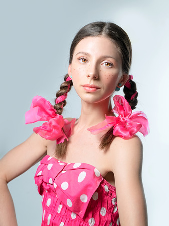 Portrait of teen girl with freckles and pigtails with pink bowsの写真素材