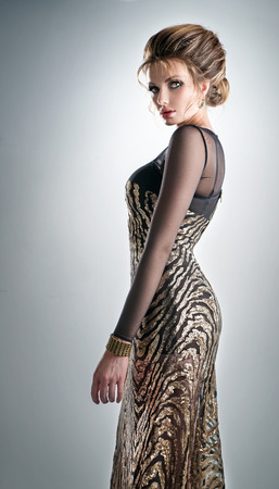Pretty woman in a long glistening dress and accessoryの写真素材
