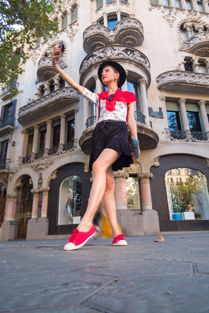 Tourism in Europe, Girl taking selfie self-portrait on smartphone on the street in Barcelonaの写真素材