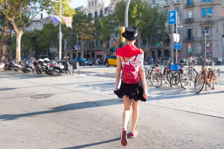 Woman tourist with backpack is walking on the street of Barcelonaの写真素材
