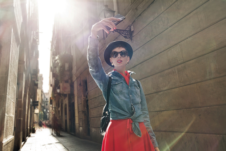Tourism in Europe, Girl taking selfie self-portrait on smartphone on the streetの写真素材