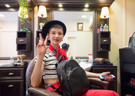 Beautiful woman sits in armchair at the hairdresserの写真素材