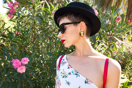 Tourism in Europe, woman tourist in black hat on flowers backgroundの写真素材