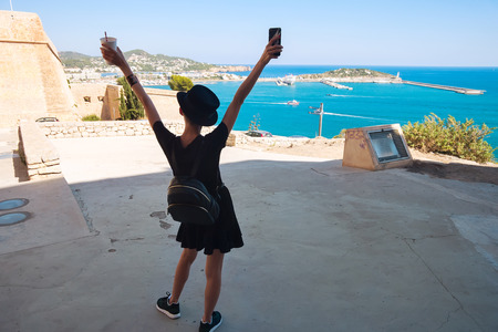 Tourism in Europe, happy woman looks at sea from high coastの写真素材