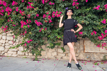 Slim girl outdoors surrounded by flowering plantsの写真素材