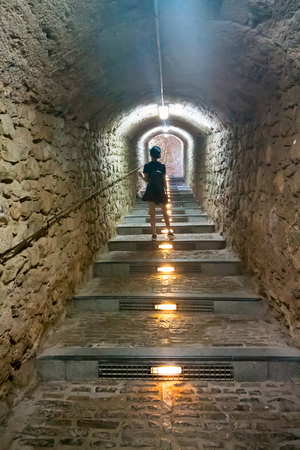 Tourism in Europe, girl goes up stairs in tunnelの写真素材
