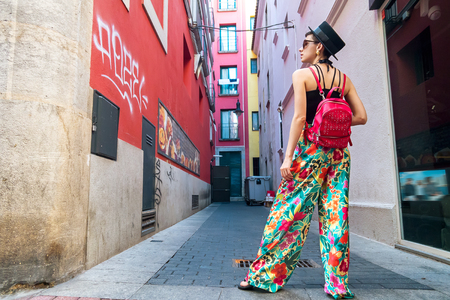 Woman with backpack in middle of narrow streetのeditorial素材