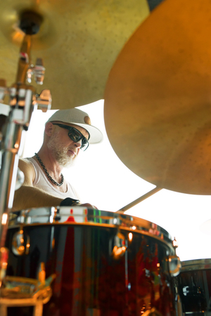 Drummer plays musical percussion instrument with drumsticksの写真素材