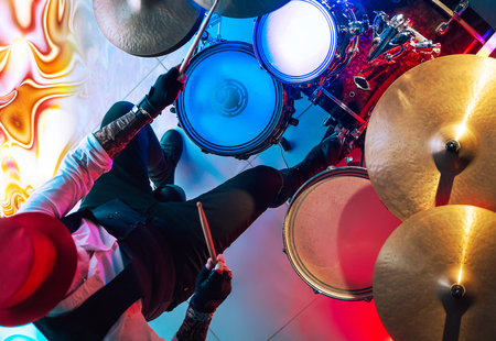 Drummer playing on drum set on stage in the color light. View from aboveの写真素材