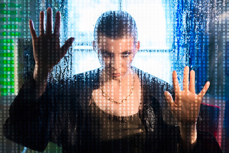 Female hacker over code backgroundの写真素材