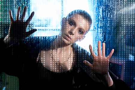 Female hacker over code backgroundの写真素材