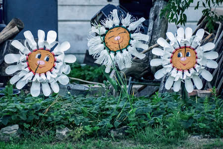 Flowers with smiles made from plastic bottles in the gardenの写真素材