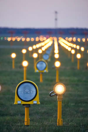 Headlights of runway lights at the airport on the background of the evening skyの写真素材