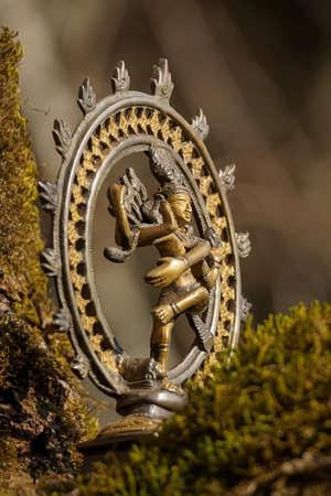 Bronze statue of indian dancing god Shiva Nataraja - Lord of Dance close up on a blurred nature...