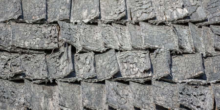 Wooden aged tile on the roof of the house, natural surface texture backgroundの写真素材