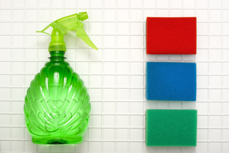 The tool for cleaning a green spray and three sponges red, blue, green against the background of white cagesの写真素材