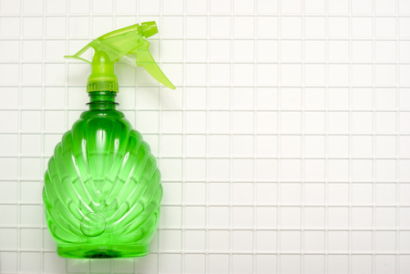 The tool for cleaning a green spray against the background of white cagesの写真素材