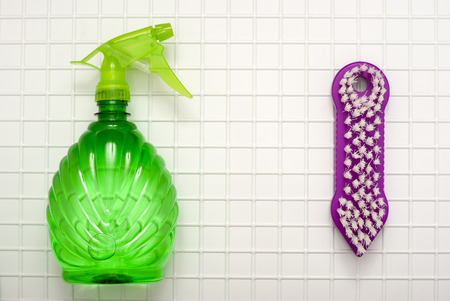 The tool for cleaning a green spray and a brush against the background of white cagesの写真素材
