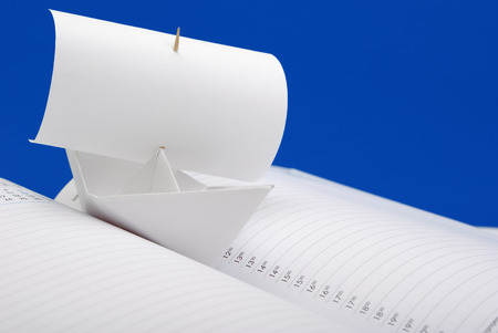White paper ship with a sail the notebook the scheduleの写真素材