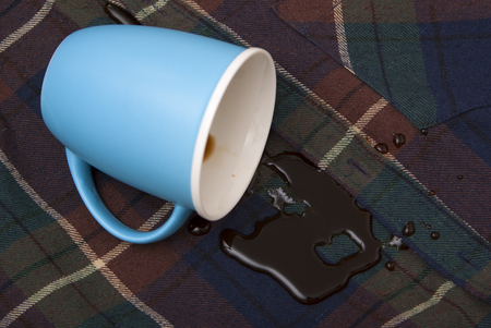 The overturned blue cup a coffee pool on a shirtの写真素材