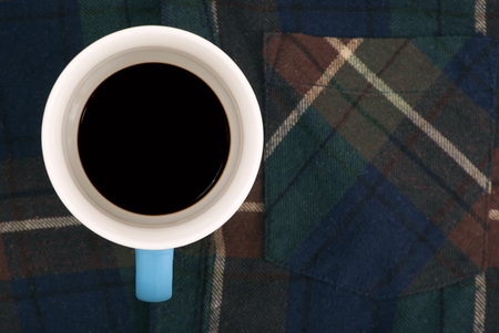 Blue cup with the blue handle on a klechaty shirt the top viewの写真素材