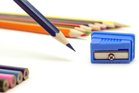 Blue sharp pencil with a blue sharpener and colored pencils on white backgroundの写真素材