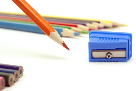 orange pencil and blue sharpener on a white backgroundの写真素材