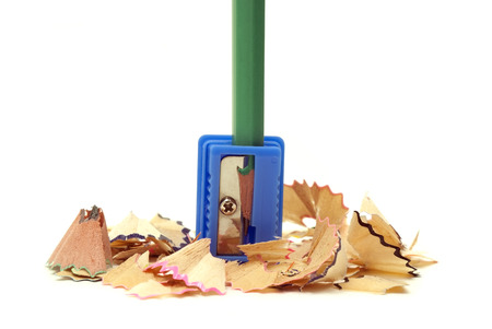 simple pencil in a blue sharpener with shaving on a white backgroundの写真素材