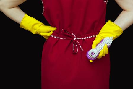 Female torso and red robe woman's hands and yellow gloves with brushの写真素材