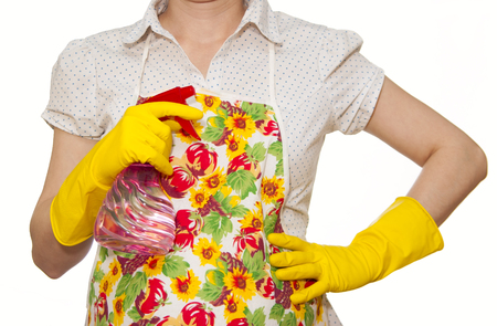 female torso in white shirt apron hand with yellow glove holding a red spray bottle on a white backgroundの写真素材