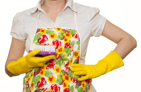 female torso in white shirt apron hand with yellow glove holding a purple brush on a white backgroundの写真素材