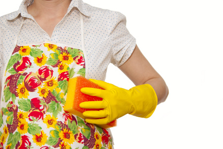 female torso in white shirt apron hand with yellow glove holding a yellow sponge with a red on a white backgroundの写真素材