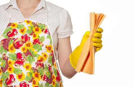 female torso in white shirt apron hand with yellow glove holding orange cloth on a white backgroundの写真素材