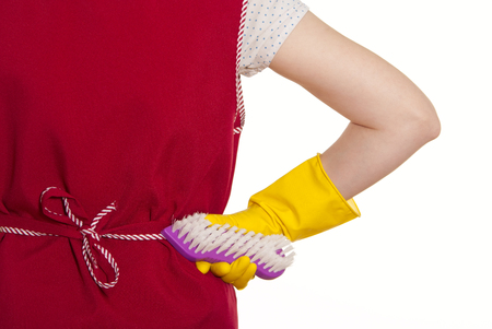 female torso in a red smock hand in yellow glove with a violet brush on a white backgroundの写真素材