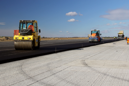 TULCEA, ROMANIA - NOVEMBER 08: Road rollers leveling fresh asphalt pavement on a runway as part of...