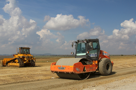 TULCEA, ROMANIA - SEPTEMBER 26: Heavy construction equipment compacting soil on a runway construction site as part of the Danube Delta international airport expansion plan on September 26,2015 in Tulcea, Romania.のeditorial素材
