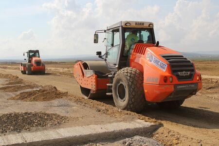 TULCEA, ROMANIA - SEPTEMBER 26: Heavy construction equipment compacting soil on a runway...