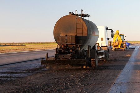 TULCEA, ROMANIA - DECEMBER 02: Oil spreader truck applying tack coats on a surface in preparation...