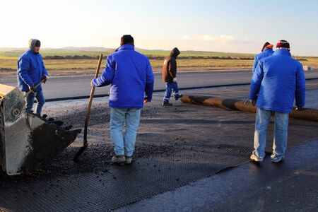 TULCEA, ROMANIA - DECEMBER 02: Workers applying reinforcement mesh on a surface in preparation for paving as part of the Danube Delta international airport on December 02, 2015 in Tulcea, Romania.のeditorial素材