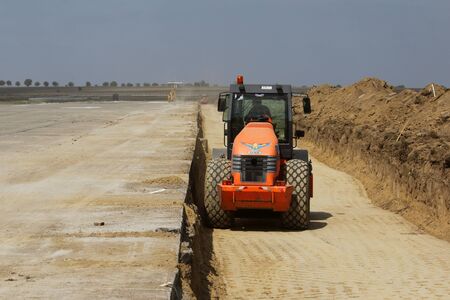 TULCEA, ROMANIA - SEPTEMBER 26: Heavy construction equipment compacting soil on a runway construction site as part of the Danube Delta international airport expansion plan on September 26,2015 in Tulcea, Romania.のeditorial素材