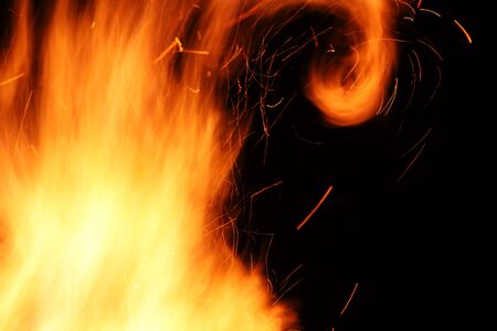 Wild yellow flames from a burning wood fire at nightの写真素材