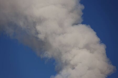 Smoke from a factory chimney releases air pollution and greenhouse gasesの写真素材