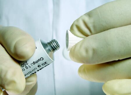 Doctor's hands opening a cream tubeの写真素材