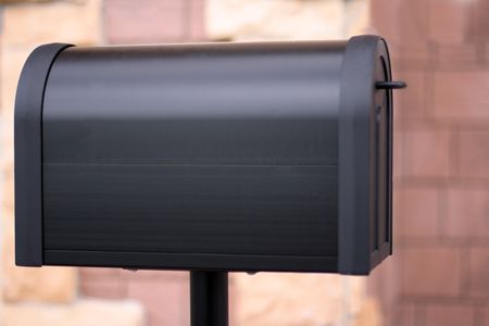 Close up image of a mailbox in front of a residential house wall.Selective focus on the left part of the box,the wall is out of focus.の写真素材