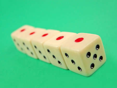 Perspective with five dice on  green surface. Selective focus on the first die.の写真素材